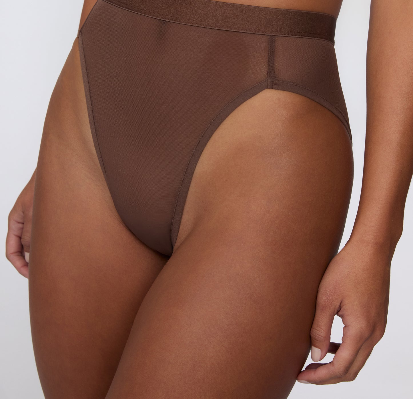 On a white studio backdrop, a close-up front view shows the ComfortMesh™ Highwaist in Cashmere worn with the matching bralette, highlighting the sheer mesh fabric, smooth waistband, and high-rise coverage.