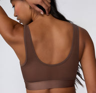 On a white studio backdrop, a back view shows Amber wearing the ComfortMesh™ Scoop Bralette in Cashmere, highlighting the scoop back, wide straps, and supportive band.