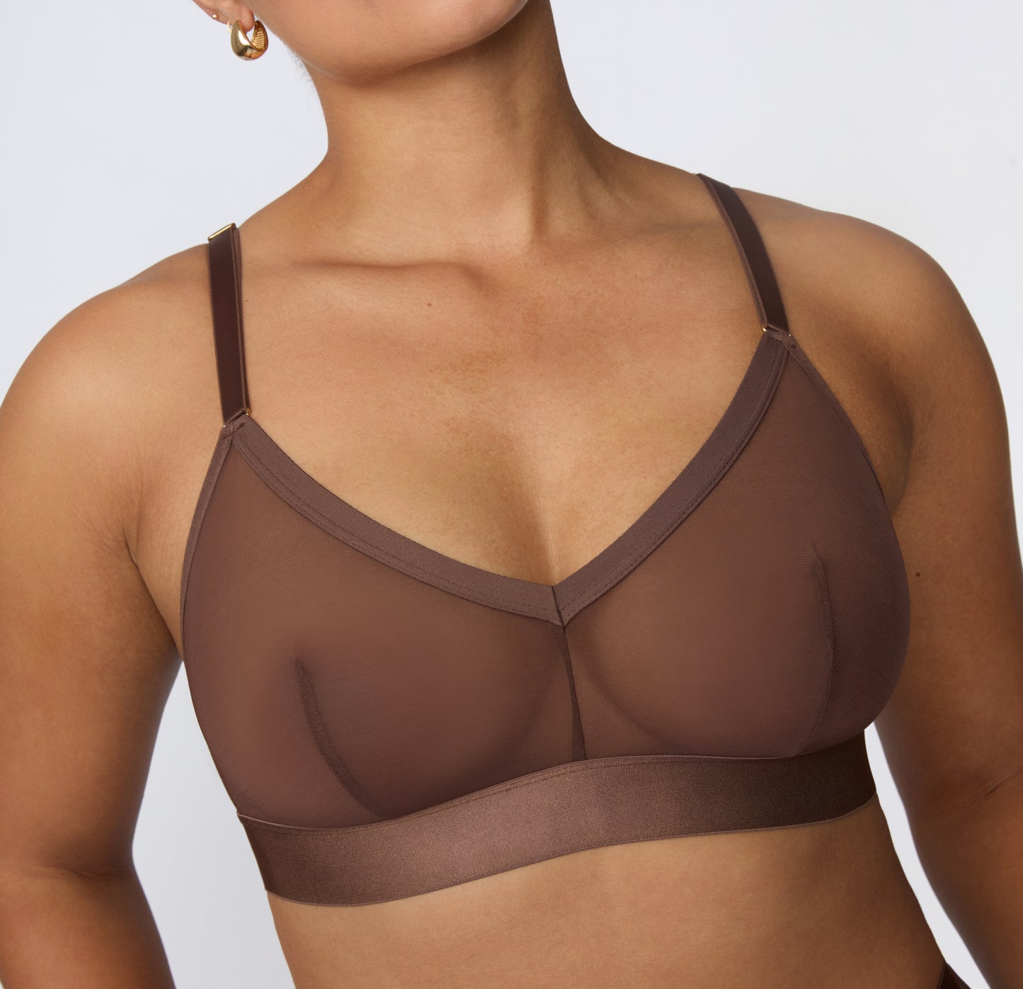 On a white studio backdrop, India wears the ComfortMesh™ Triangle Bralette in Cashmere, showing the adjustable straps, sheer mesh cups, and soft wide band designed for everyday comfort.