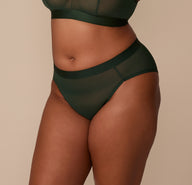 Three-quarter side view of Zarria wearing the ComfortMesh™ Highwaist Brief in Sequoia, emphasizing the flattering high leg cut and soft stretch waistband.