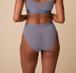 Back view of Ally wearing the ComfortMesh™ Highwaist Brief in Steel. The image showcases the full back coverage and smooth, seamless look of the mesh fabric.