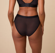 Rear view of the ComfortMesh™ Highwaist Brief in Black. The sheer back fabric hugs the body smoothly, emphasizing the high-rise cut for added coverage and comfort.
