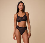 Full-body view of a model wearing the ComfortMesh™ Highwaist Brief in Black paired with the matching Triangle Bralette. The high-rise fit and sheer detailing highlight a modern and supportive design.