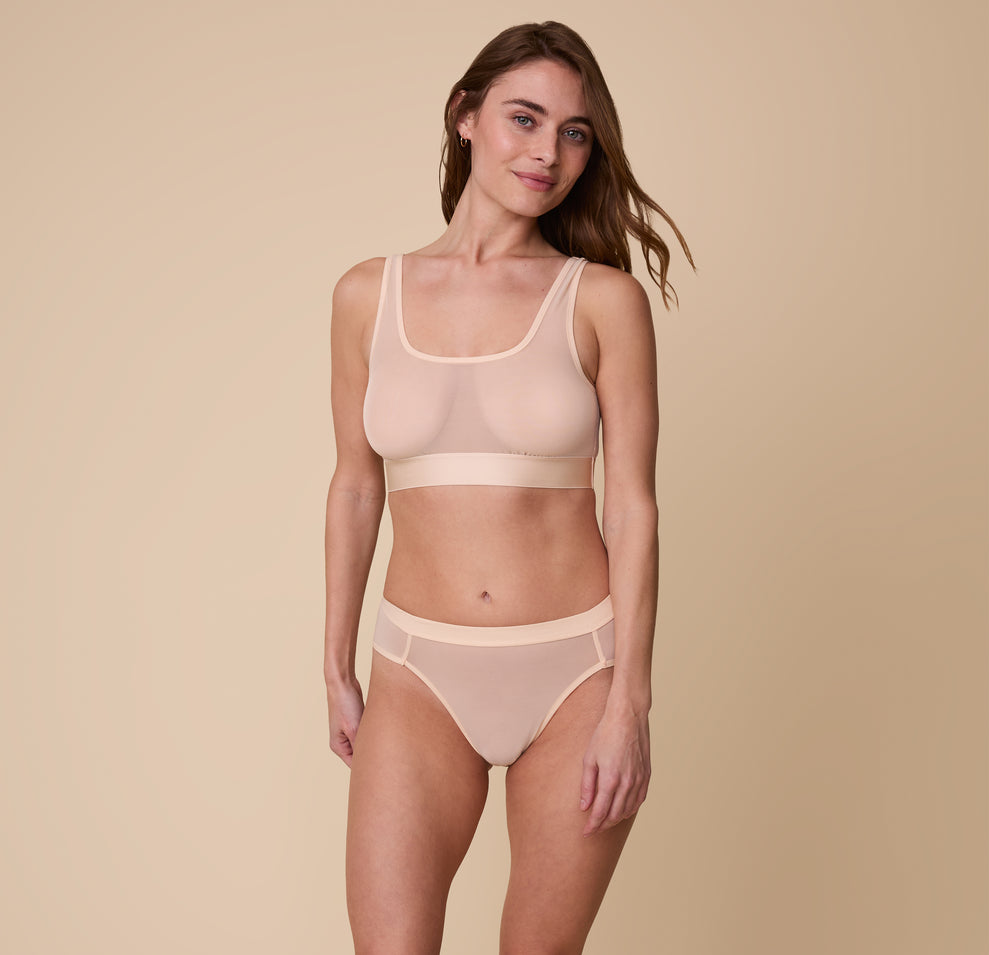 Full-body view of Gracie wearing the ComfortMesh™ Highwaist Brief in Pearl paired with the matching Scoop Bralette. The breathable material and high leg detail offer an elevated and supportive style.