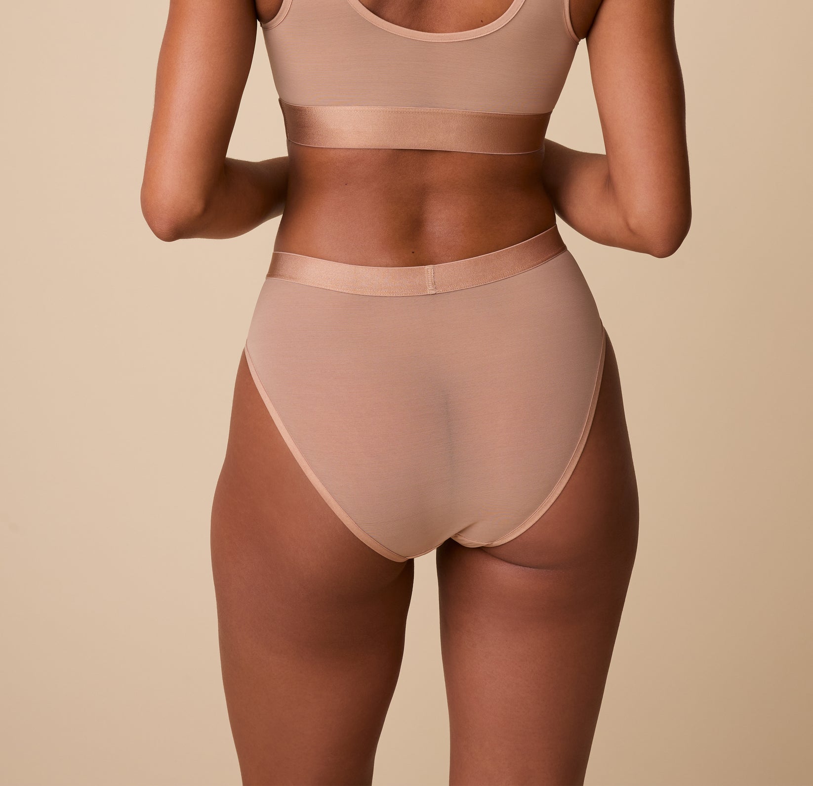 Back view of the taupe highwaist briefs, showing the smooth finish across the waist and hips, with soft edges.