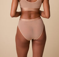 Back view of the taupe highwaist briefs, showing the smooth finish across the waist and hips, with soft edges.