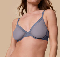 Close-up angled view of Gracie wearing the ComfortMesh™ Plunge Bra in Steel. The image draws attention to the soft mesh texture and deep V cut of the bra.
