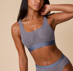 Ally wearing the ComfortMesh™ Scoop Bralette in Steel, shown from the front at a slight angle. The image highlights the wide scoop neckline, breathable mesh fabric, and wide elastic underband for soft support. sizing: Ally wears size Small