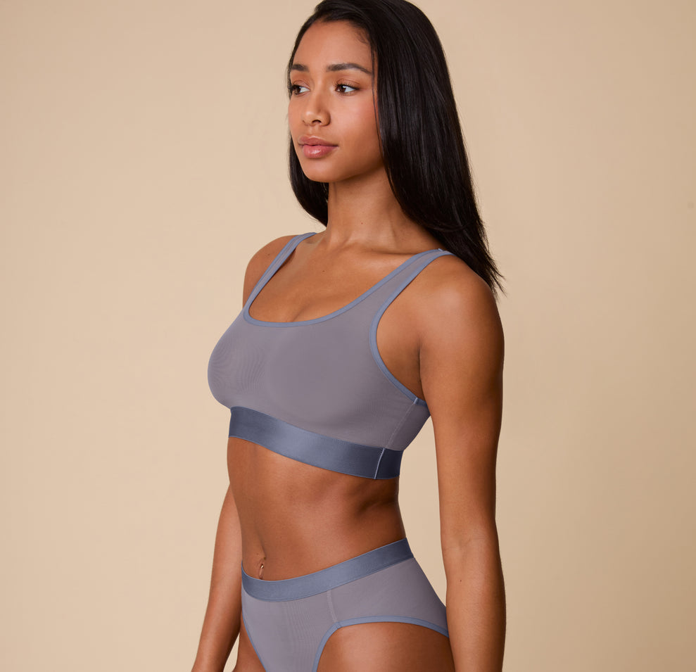Side view of Ally wearing the ComfortMesh™ Scoop Bralette and matching Highwaist Brief in Steel. The photo emphasizes the smoothing mesh coverage and supportive silhouette.