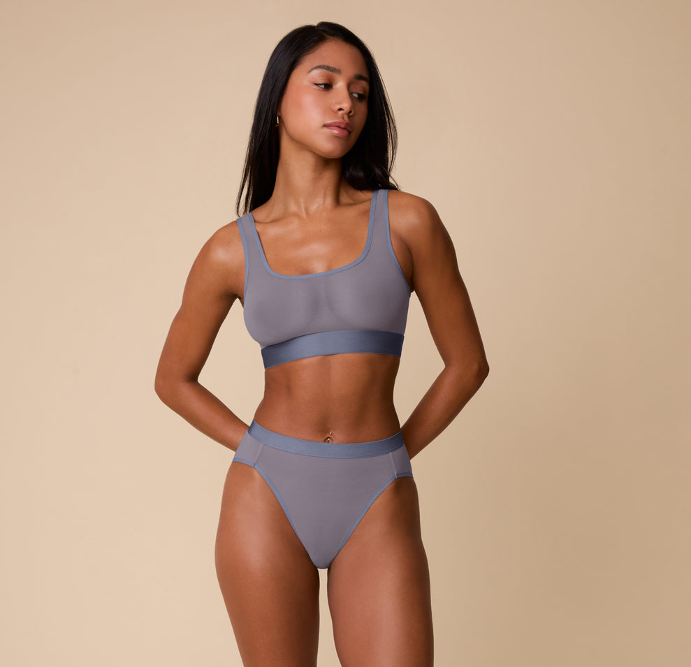 Full front view of Ally modeling the ComfortMesh™ Scoop Bralette and Highwaist Brief in Steel. The image showcases the set’s sheer, lightweight design and sporty yet soft structure.