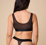 Back view of the model in the ComfortMesh™ Scoop Bralette in Black. The scoop-back design highlights the soft, stretchable band for a secure and comfortable fit.