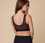 Rear three-quarter view of Gracie wearing the ComfortMesh™ Scoop Bralette in Black. The flexible fabric and wide band create a supportive yet breathable fit.