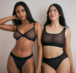 Ally and Emersyn standing side by side, showcasing the ComfortMesh™ collection. One wears the ComfortMesh™ Scoop Bralette in Black with matching briefs, and the other wears the ComfortMesh™ Plunge Bra in Black with matching underwear, highlighting the variety in styles within the collection.