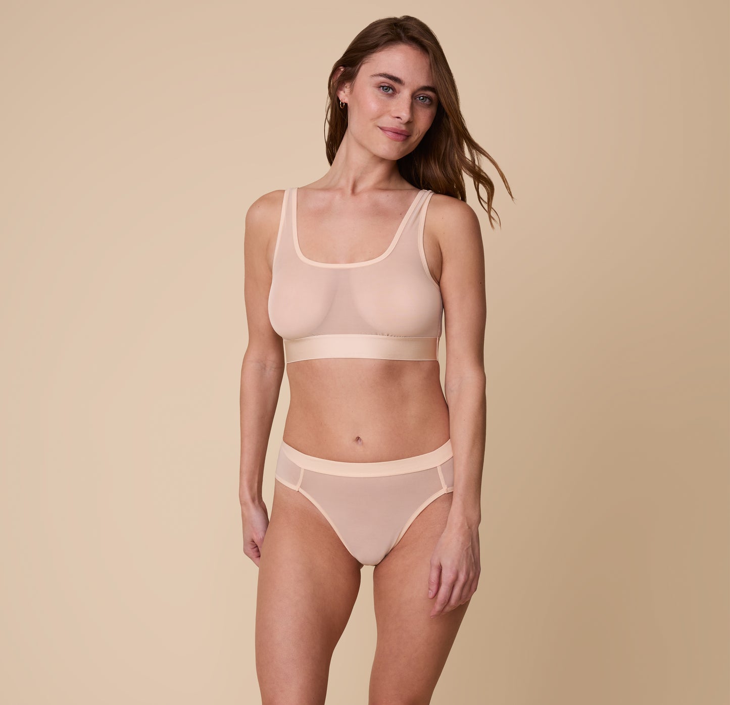 Full-body image of the model wearing the ComfortMesh™ Scoop Bralette and matching ComfortMesh™ Highwaist Brief in Pearl. The sheer fabric highlights the smooth fit and light support of both pieces.