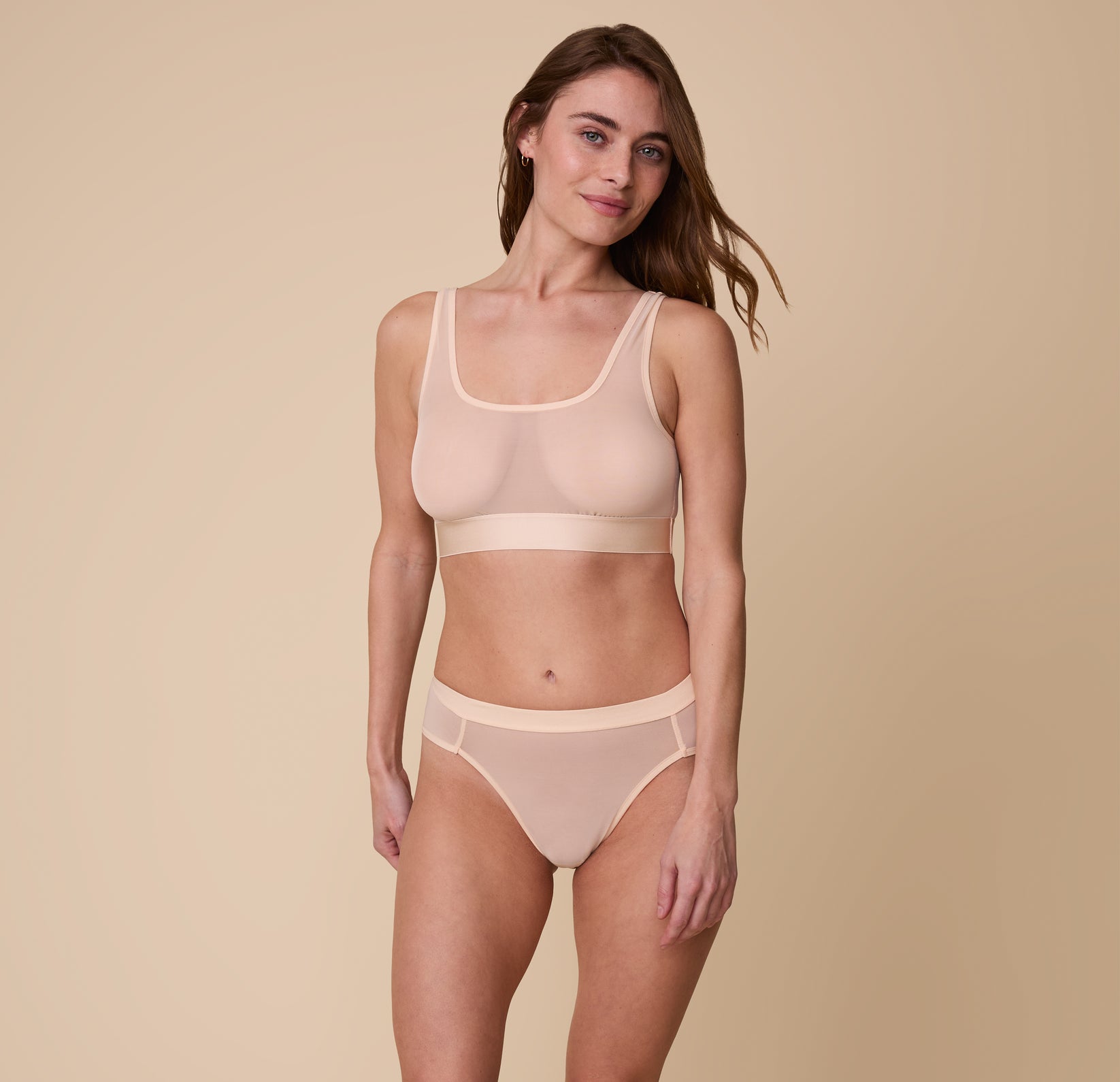 Full-body image of the model wearing the ComfortMesh™ Scoop Bralette and matching ComfortMesh™ Highwaist Brief in Pearl. The sheer fabric highlights the smooth fit and light support of both pieces.