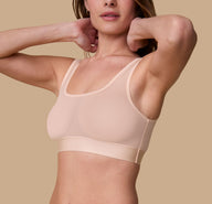 3/4th profile of the model wearing the ComfortMesh™ Scoop Bralette in Pearl. The wide, supportive band and soft, flexible fabric create a comfortable fit. sizing: Gracie wears a size Small