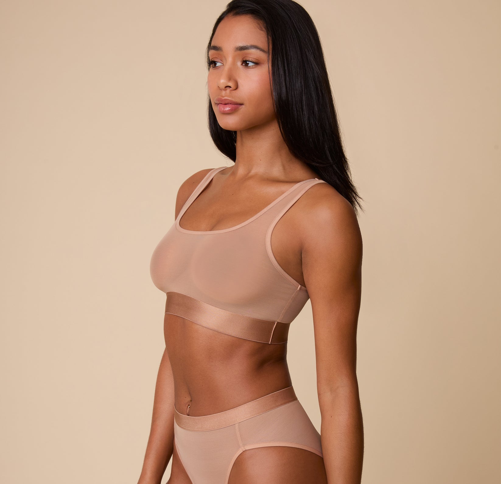 Three-quarter side view of Ally in the ComfortMesh™ Scoop Bralette in Taupe. The sheer fabric provides a flexible fit while maintaining support. 