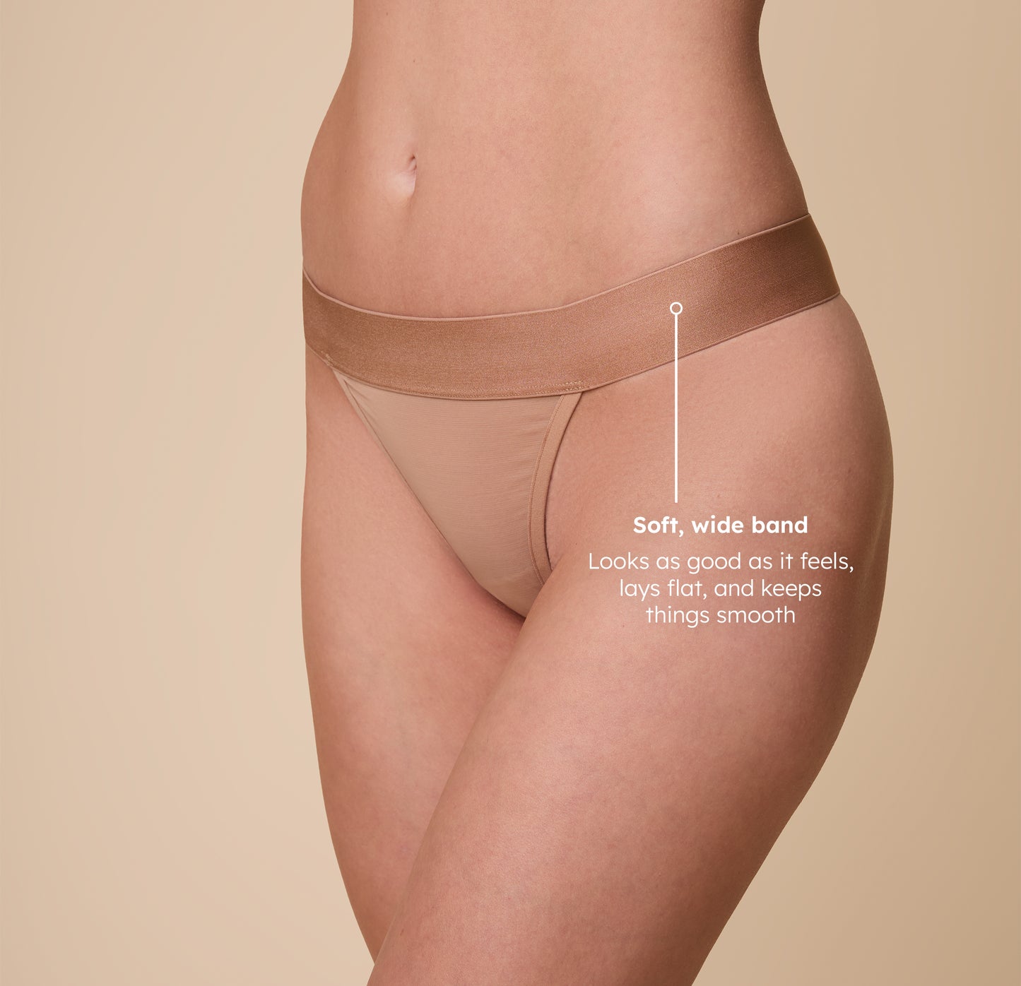 A close-up shot of Gracie wearing the ComfortMesh™ Thong in Taupe. The image features a tagline reading, “Soft, wide band – Looks as good as it feels, lays flat, and keeps things smooth,” emphasizing the thong’s comfort and practicality.