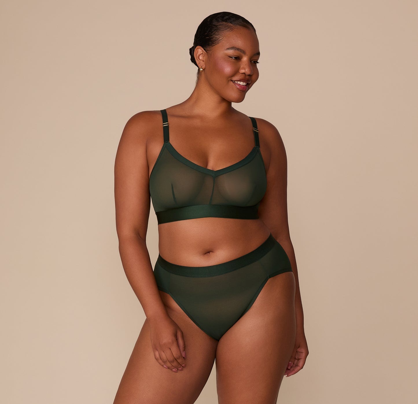 Zarria standing in the full ComfortMesh™ set in Sequoia, including the Triangle Bralette and Highwaist Brief. The sheer matching pieces offer light support and all-day comfort.