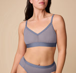 Emersyn wearing the ComfortMesh™ Triangle Bralette in Steel. The front view shows the deep V neckline, wide elastic band, and breathable mesh cups designed for wire-free support. sizing: Emersyn wears size Medium