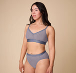 Angled side view of Emersyn modeling the ComfortMesh™ Triangle Bralette and matching Highwaist Brief in Steel. The photo emphasizes the mesh construction and smooth finish.
