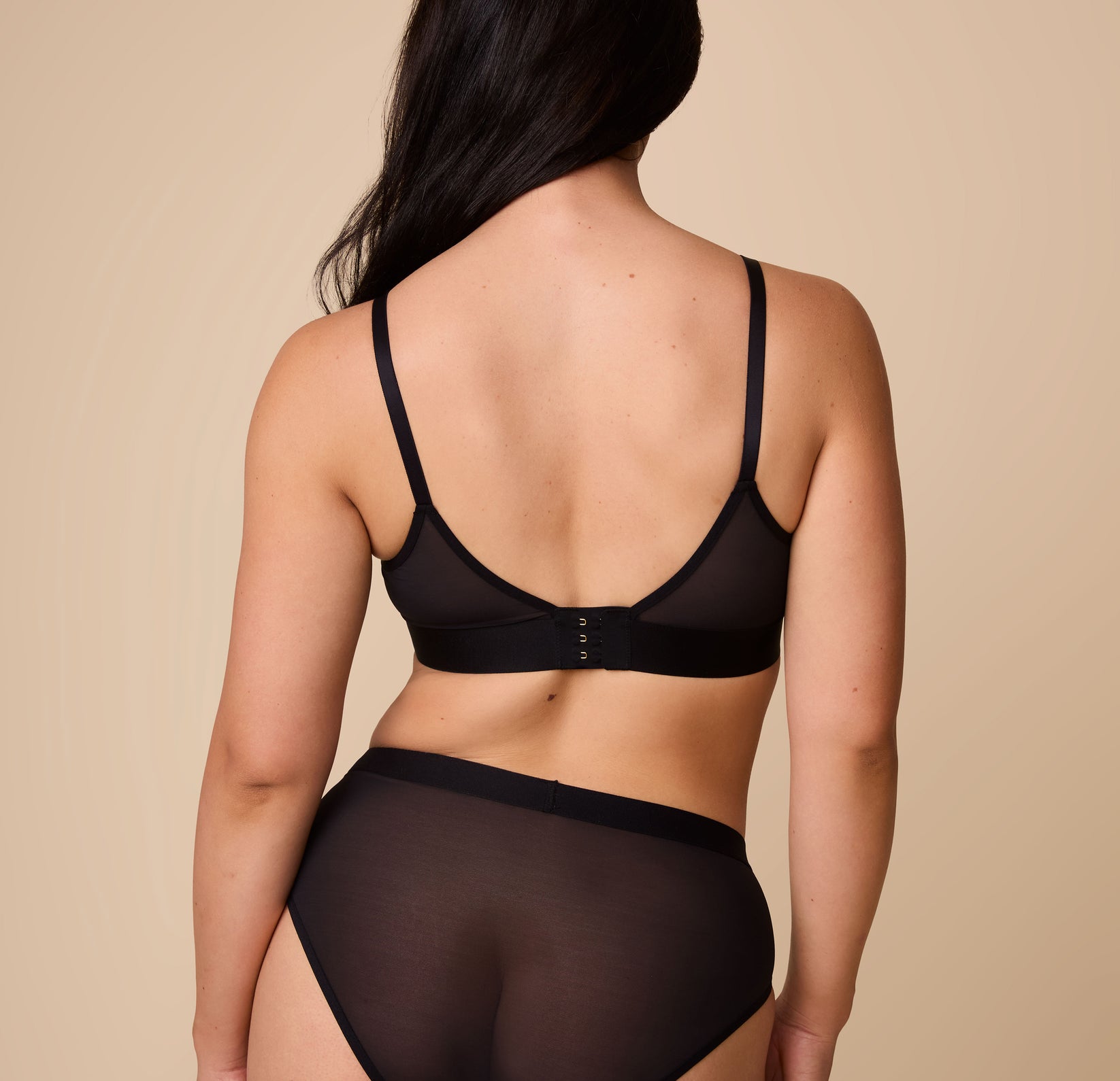 Rear view of Emersyn wearing the ComfortMesh Triangle Bralette in Black, highlighting the smooth finish and wide band. 