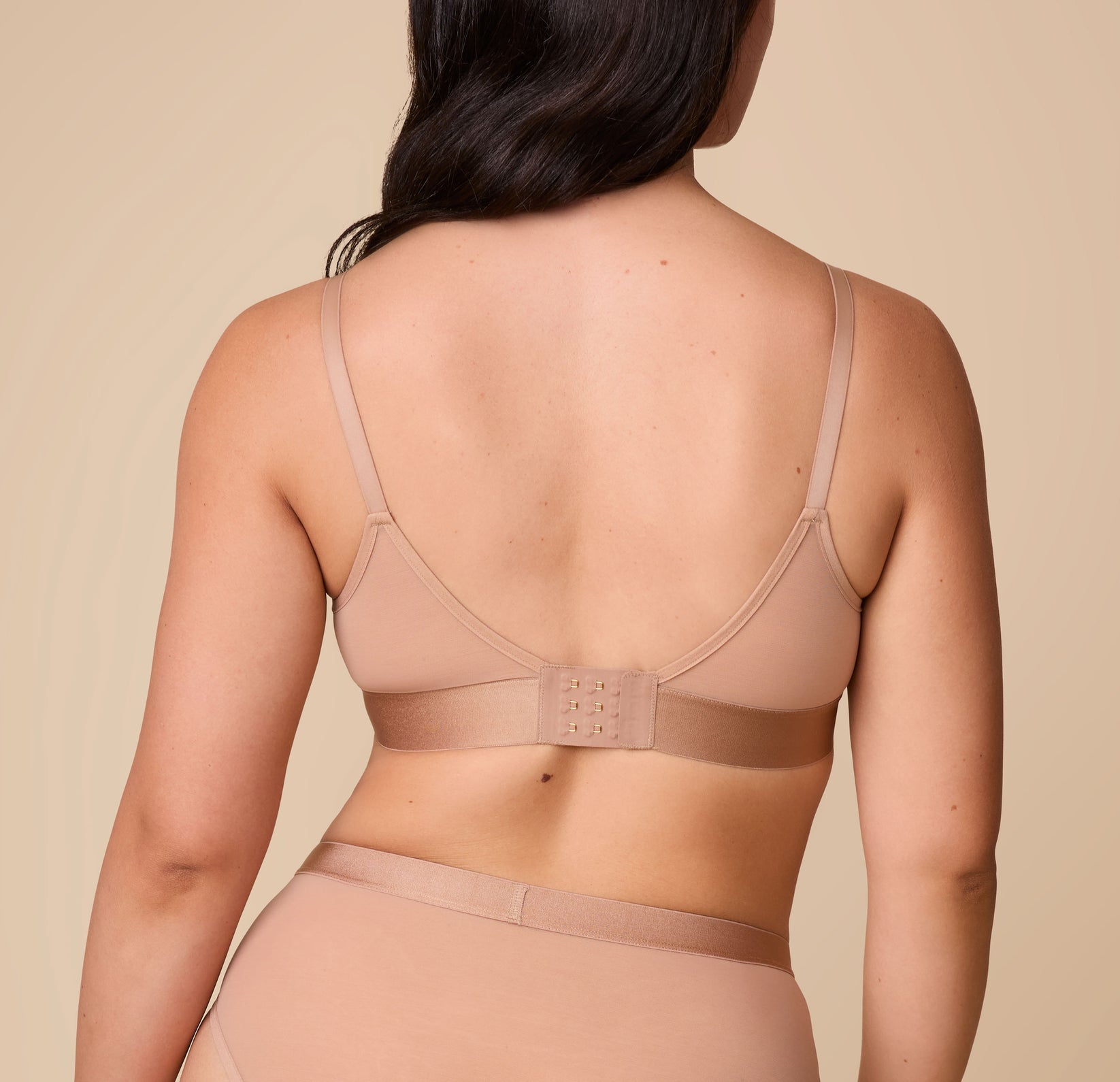 A back view of Emersyn wearing the ComfortMesh™ Triangle Bralette in Taupe, highlighting the comfortable straps and hook-and-eye closure.