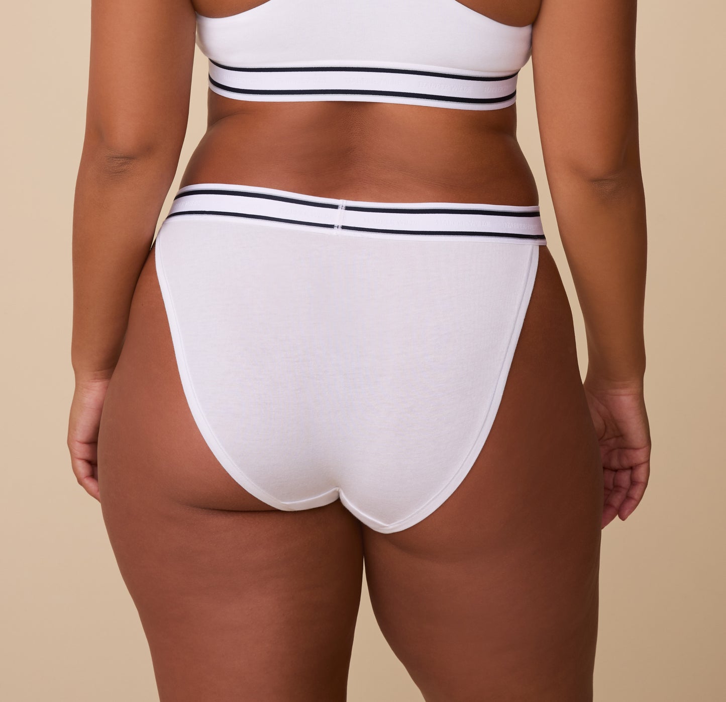 Back view of India in the Cloud Cotton Retro French Cut Bikini in White, showcasing the moderate coverage and smooth fit against the skin.