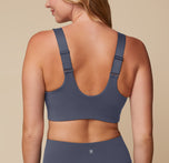 Back view of Megan wearing the Flex Convertible Sports Bra and Flex High Rise Legging in Slate, turned to display the adjustable and convertible straps. 