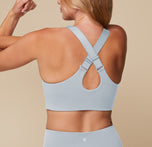 Megan showing the back of the Flex Convertible Sports Bra in Thistle with the straps adjusted to cross in the back.