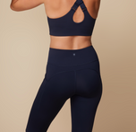 Back view of Megan wearing the Flex High Rise Legging in Ink. The small Harper Wilde logo is shown on the outside of the waistband, emphasizing how there are no tags for a comfortable fit.