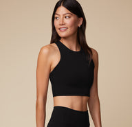 Three quarters angle of Anna wearing the Flex Racerback Sport Tank in Black. The high neckline and comfortable, yet compressive fabric is emphasized. 