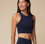 Anna in the Flex Racerback Sport Tank and Flex High Rise Leggings in Ink, smiling while turned to the side. The tank's fitted design pairs with the stretchy and compressive fit of the leggings, perfect for movement and comfort.