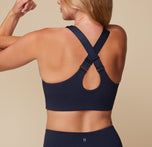 Back view of Megan wearing the Flex Convertible Sports Bra in Ink. The bra's straps are converted into a racerback to show the comfort and versatility. 