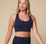 Front view of Megan in the Flex Convertible Sports Bra in Ink. The soft, supportive material and wide scoop neckline are em[hasized.