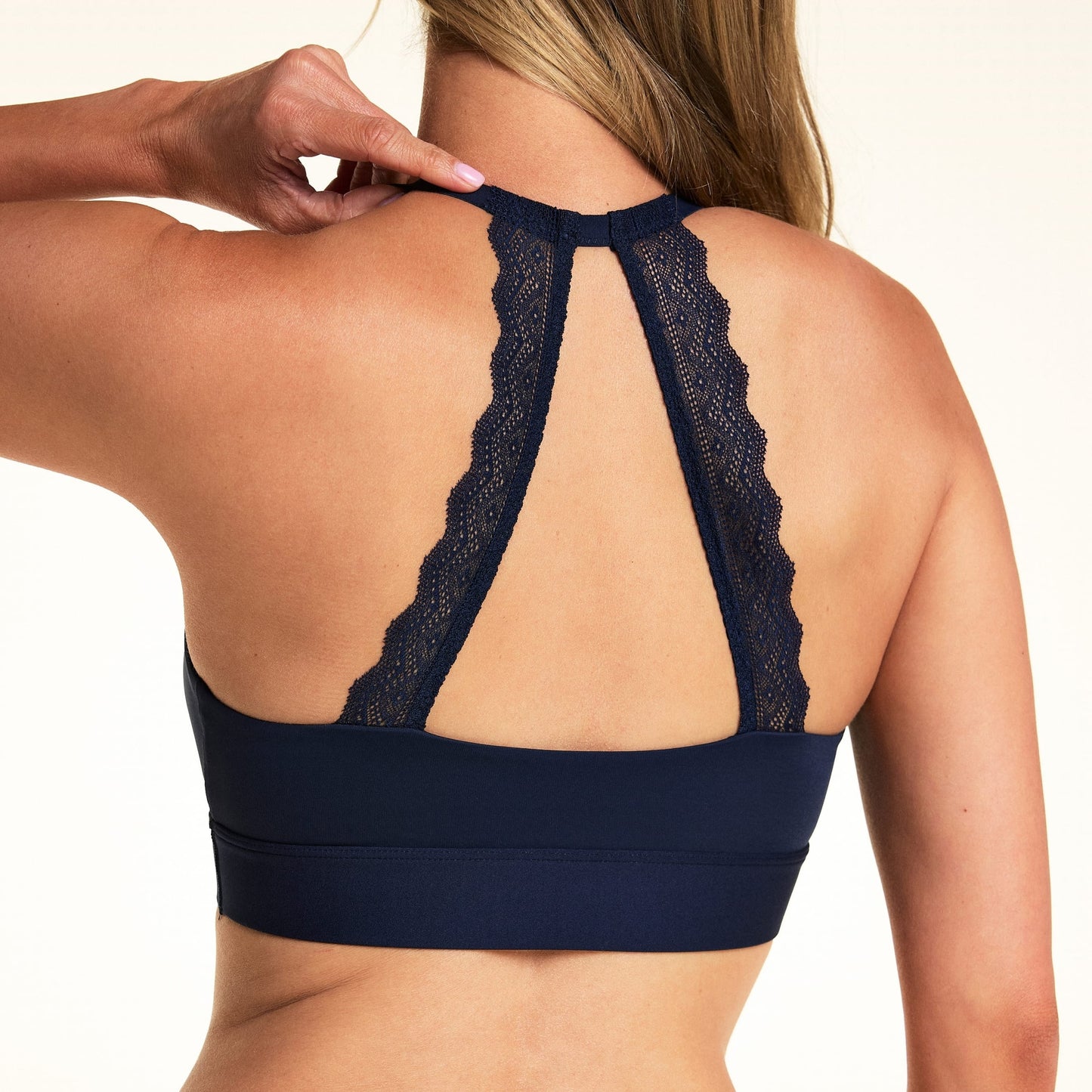 Back view of model wearing the Bliss Lace Halterneck Bralette in Navy, showcasing the signature lace back panel.