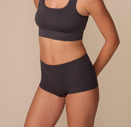 Side angle shot of Alexis in the Lounge Rib Boyshort in Charcoal, showing the soft ribbing, snug leg openings, and high-stretch material that contours naturally to her shape.