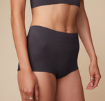 Close up view of Anna wearing the Lounge Rib Boyshort in Charcoal. The wide comfortable waistband and ribbed material are emphasized.