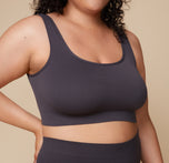 Close-up shot of Bianca wearing the Lounge Rib Scoop Bralette in Charcoal, emphasizing the soft ribbed texture and scoop neckline.