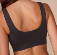 Zoomed-in back detail of the Lounge Rib Scoop Bralette in Charcoal on Alexis, showcasing the ribbed fabric and seamless edges that lie flat against the skin.