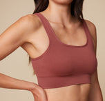 Close-up shot of Anna wearing the Lounge Rib Scoop Bralette in Clay, focusing on the ribbed texture and scoop neckline.