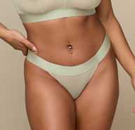 Close-up of the Luxe Thong in Moondust on the model, emphasizing the soft, lightweight fabric and comfortable waistband.