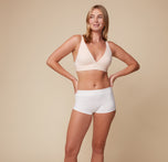 Model Megan stands confidently in the Lounge Boyshort in White and Bliss Plunge Adjustable Bralette in Rose, showcasing the comfortable fit of both pieces against a neutral background.