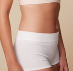 Close-up of model Megan’s midsection wearing the Lounge Boyshort in White and Bliss Plunge Adjustable Bralette in Rose, emphasizing the soft, stretchy fabric.