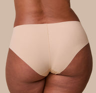 A close-up back angle of the No-Show Hiphugger in Beige, showcasing the raw-edge finish and lightweight, smoothing fabric from the back.