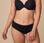 A natural movement shot of Emersyn in the No-Show Hiphugger in Black paired with the matching Base T-Shirt Bra, highlighting the effortless comfort and barely-there feel of the design. sizing: Emersyn wears size Large