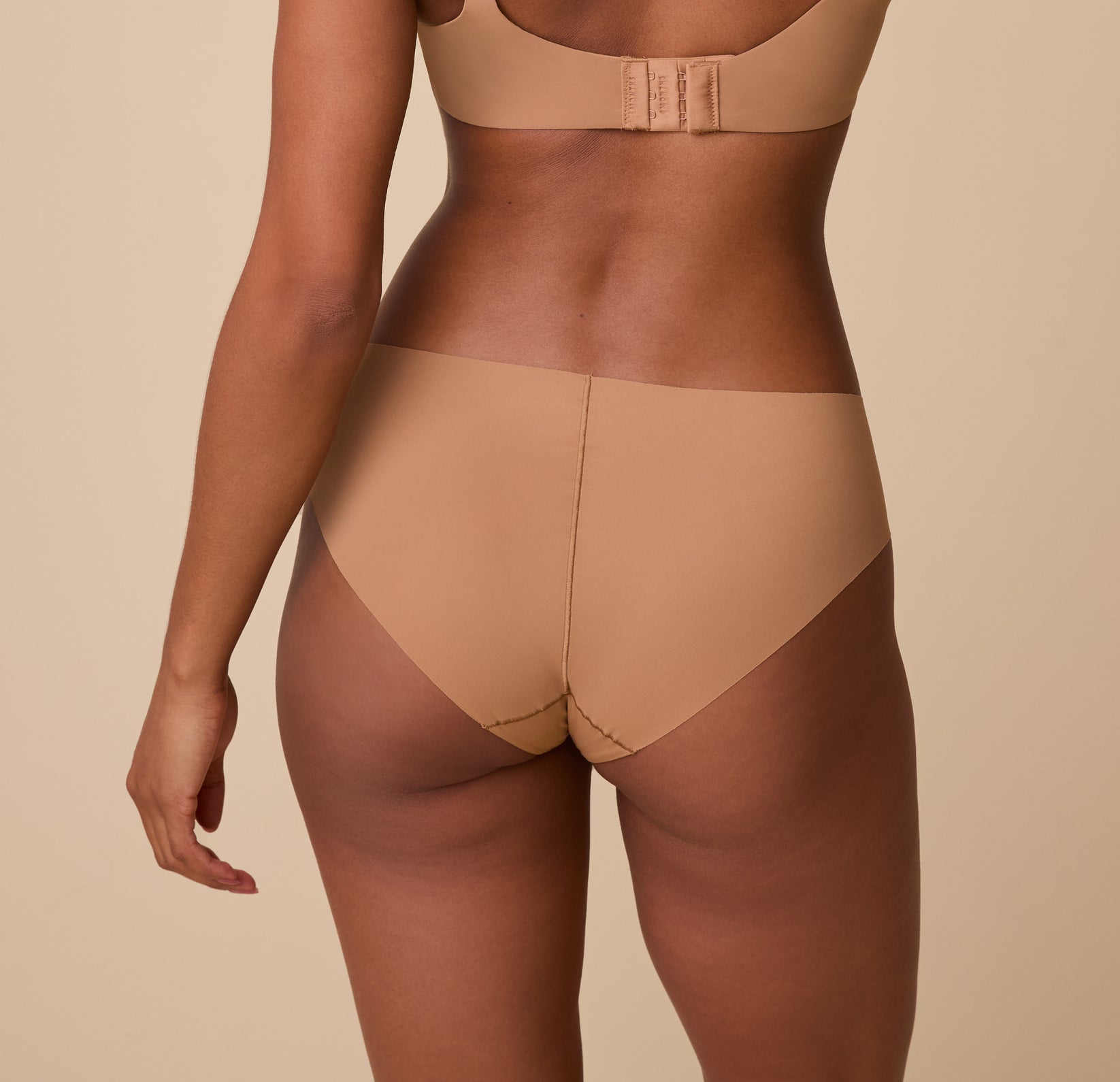 Ally is shown from behind, highlighting the full-coverage back and raw-cut edges for a sleek, no-show finish.