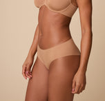 A three quarter profile of Ally in the No-Show Hiphugger in Tan, emphasizing the soft, elastic-free waistband and invisible fit.