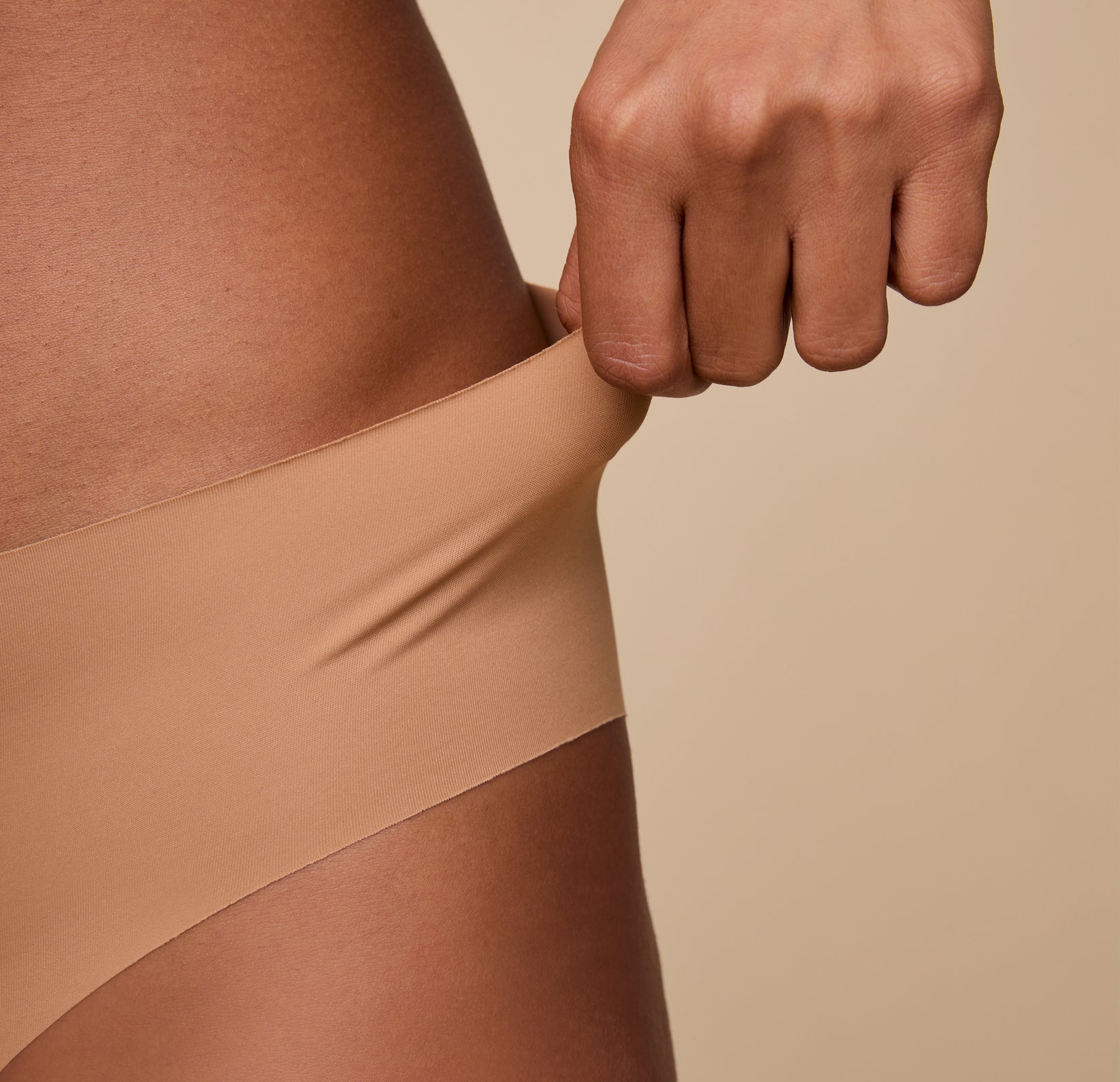 A zoomed-in view of Ally stretching the waistband, highlighting the seamless construction and comfortable elasticity.