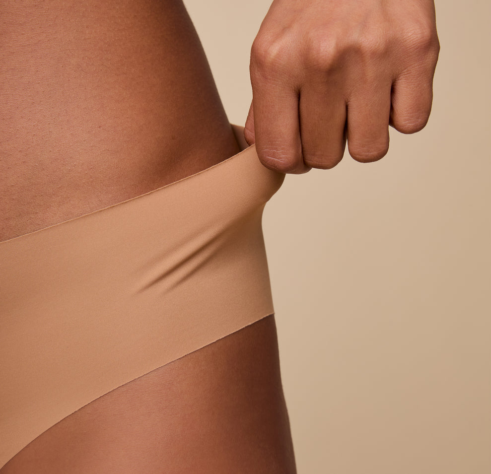 A zoomed-in view of Ally stretching the waistband, highlighting the seamless construction and comfortable elasticity.
